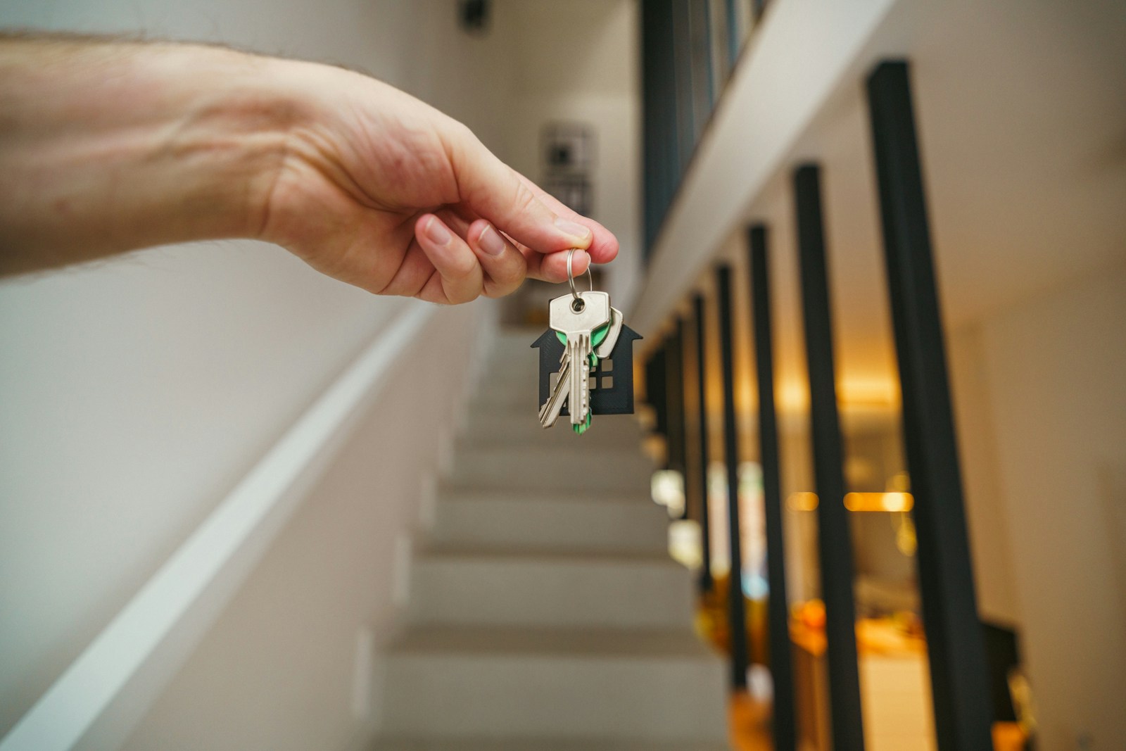 Here's a possible caption: keys being held in front of a staircase